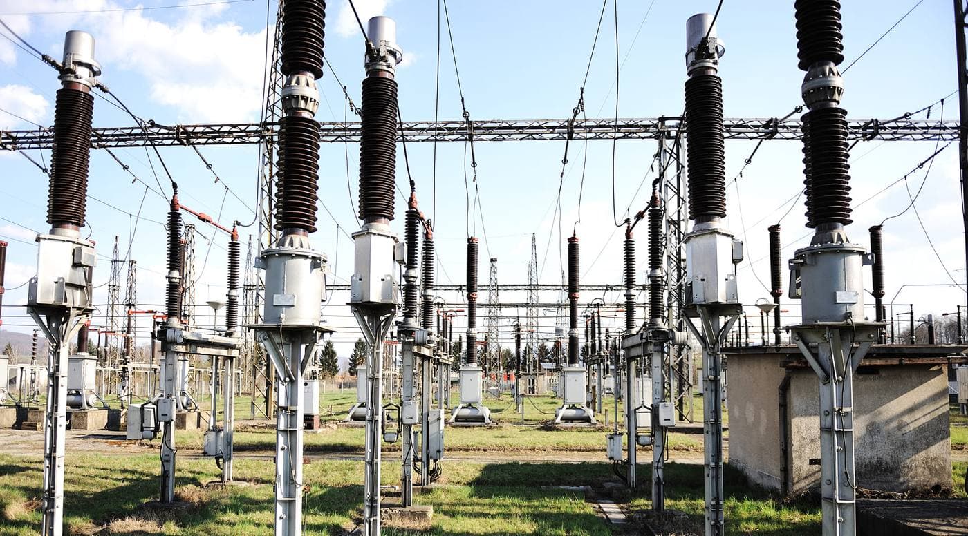 Subestación eléctrica con aisladores y estructuras metálicas